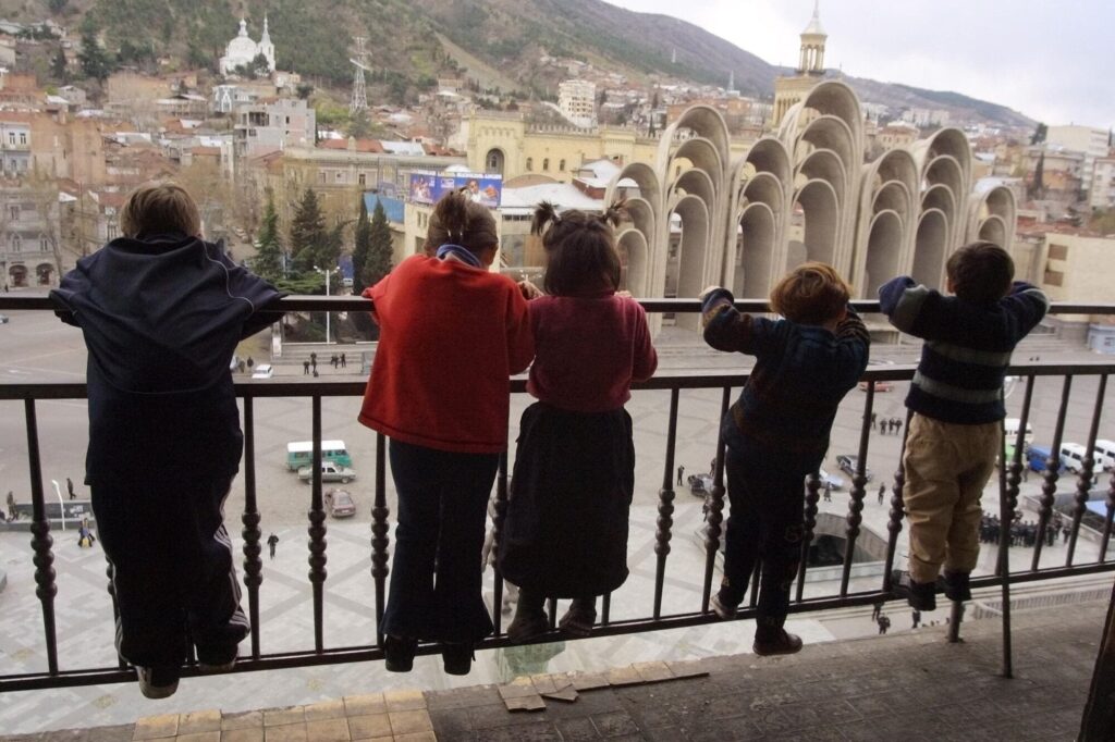 Children play on the balcony of the Hotel Iveriya in Tbilisi, Georgia, on April 2, 2002. © Oleg Nikishin/Getty