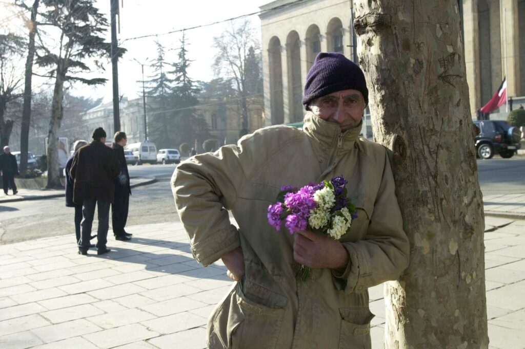 A man sells flowers in front of the Kashveti Cathedral in Tbilisi, Georgia, on February 11, 2001. © Scott Peterson/Liaison/Getty