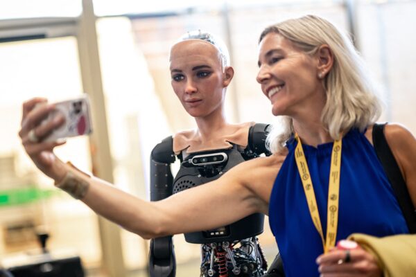 A visitor takes a selfie with a robot on July 5, 2023. © Fabrice Coffrini/AFP/Getty