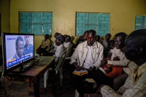 People watch a broadcast of the International Criminal Court trial of former child soldier-turned-warlord Dominic Ongwen in Lukodi, Uganda, on December 6, 2016. © Isaac Kasamani/AFP/Getty